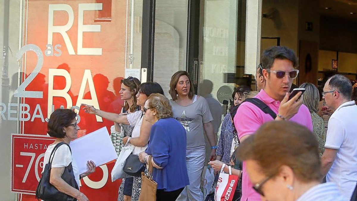 Momento de gran afluencia a la salida de un comercio durante los primeros días de las rebajas de julio.-J. M. LOSTAU