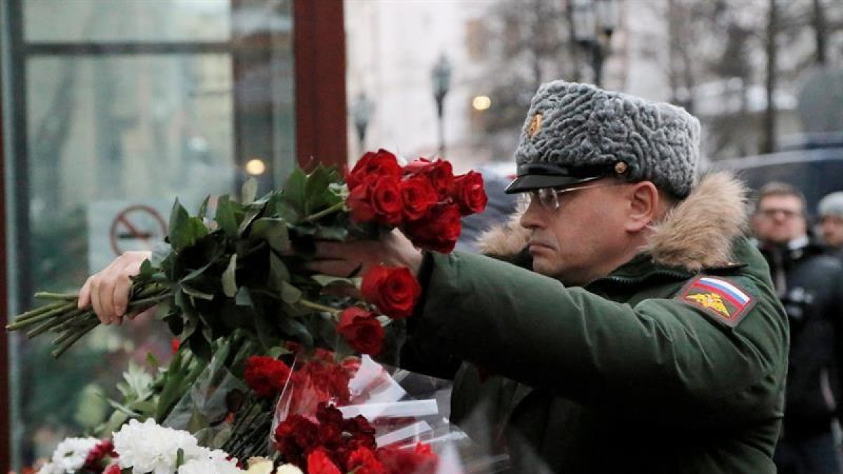 Un soldado ruso deposita flores en un pequeño altar montado ante la sede del Alexandrov Ensemble (El coro del Ejército Rojo) en Moscú (Rusia) ayer, 26 de diciembre de 2016.-EFE