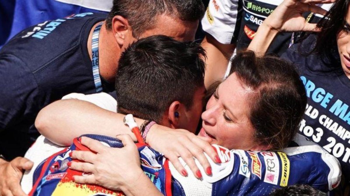 Ángel Martín y Susana Almoguera se abrazan a su hijo Jorge y lloran de felicidad en el corralito de Sepang.-ALEJANDRO CERESUELA