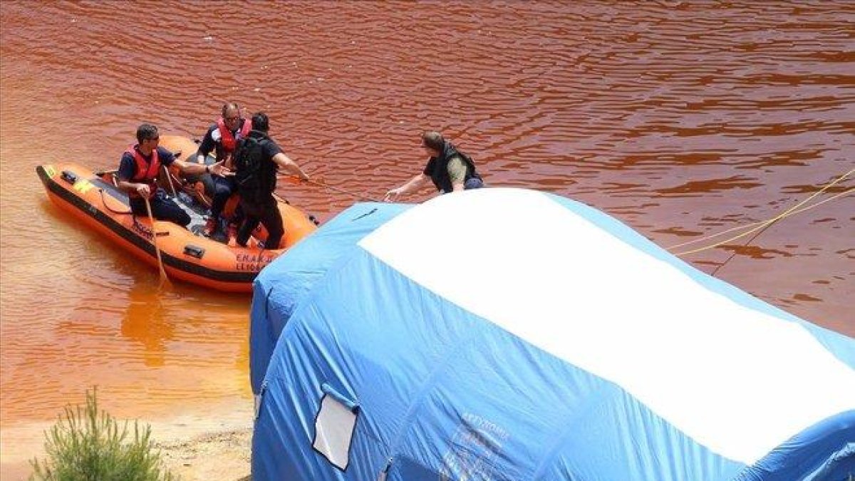 Miembros de los servicios de rescate navegan por el Lago Rojo mientras buscan nuevas pistas de los crímenes.-EFE