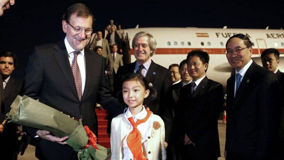 El presidente del Gobierno, Mariano Rajoy (i), junto al primer ministro Chino, Li Keqiang (d), y el embajador español en el país asiático, Manuel María Valencia Alonso ( centro detrás), a su llegada al aeropuerto de Shanghai.-Foto: EFE