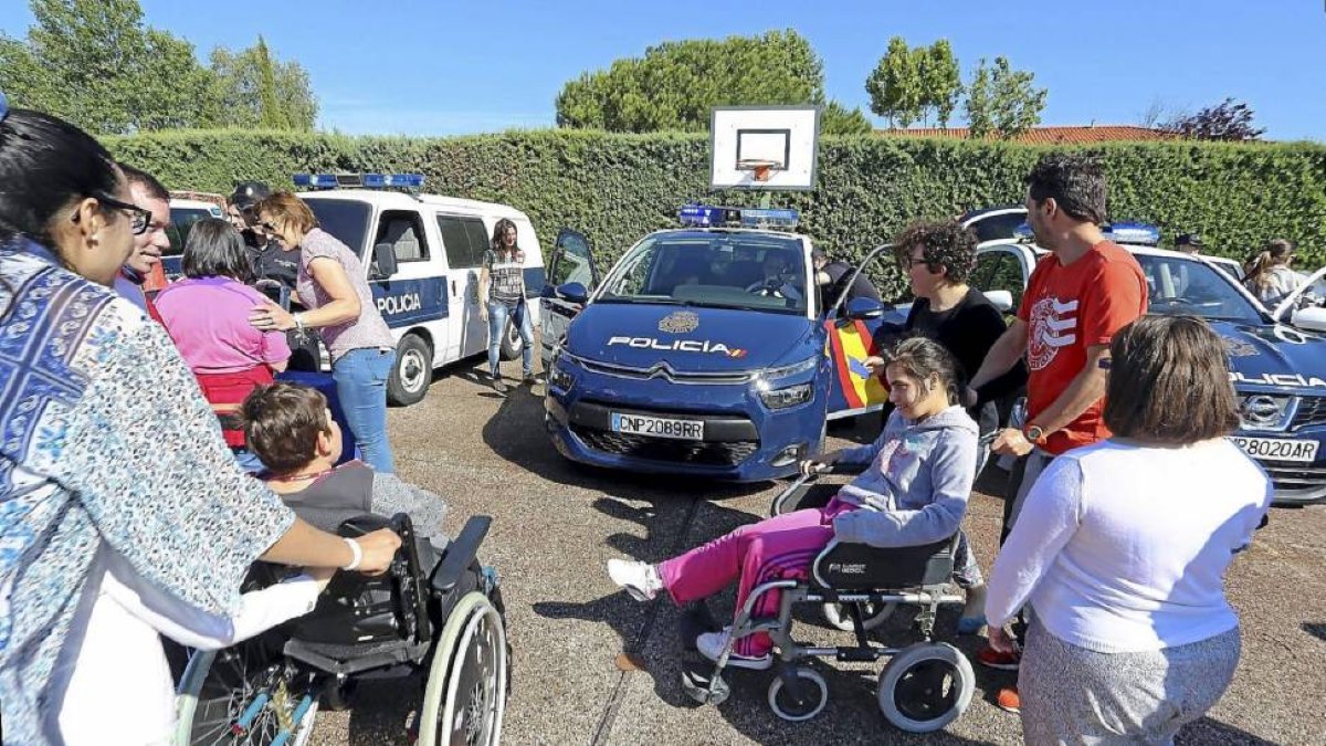Niños y jóvenes pertenecientes a Asprona montan en algunos vehículos policiales durante el acto de clausura del Plan para la Convivencia.-ICAL