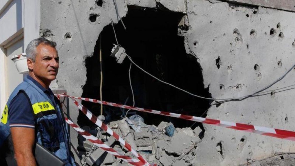 Un israelí inspecciona una casa dañada en la franja de Gaza.-COHEN MAGEN (AFP)