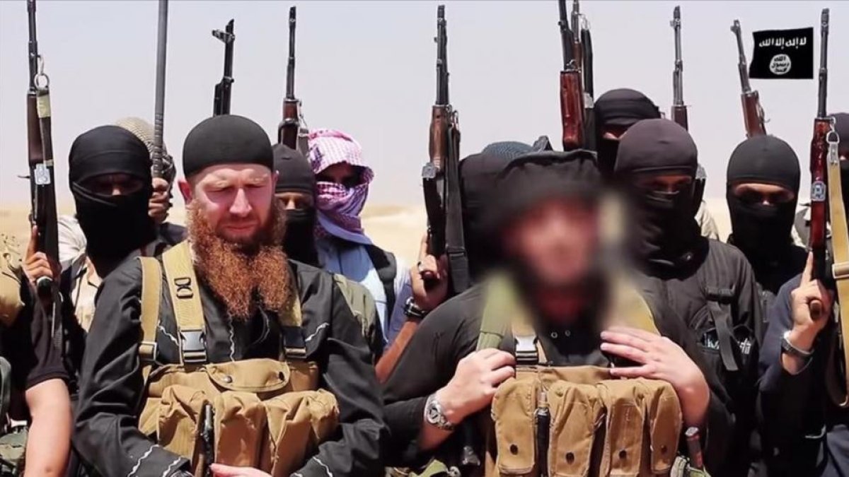 Imagen difundida por el EI en la que aparece Adnani (en primer plano, a la derecha) con el rostro difuminado para esconder su identidad, en un lugar indeterminado, en junio del 2014.-AFP