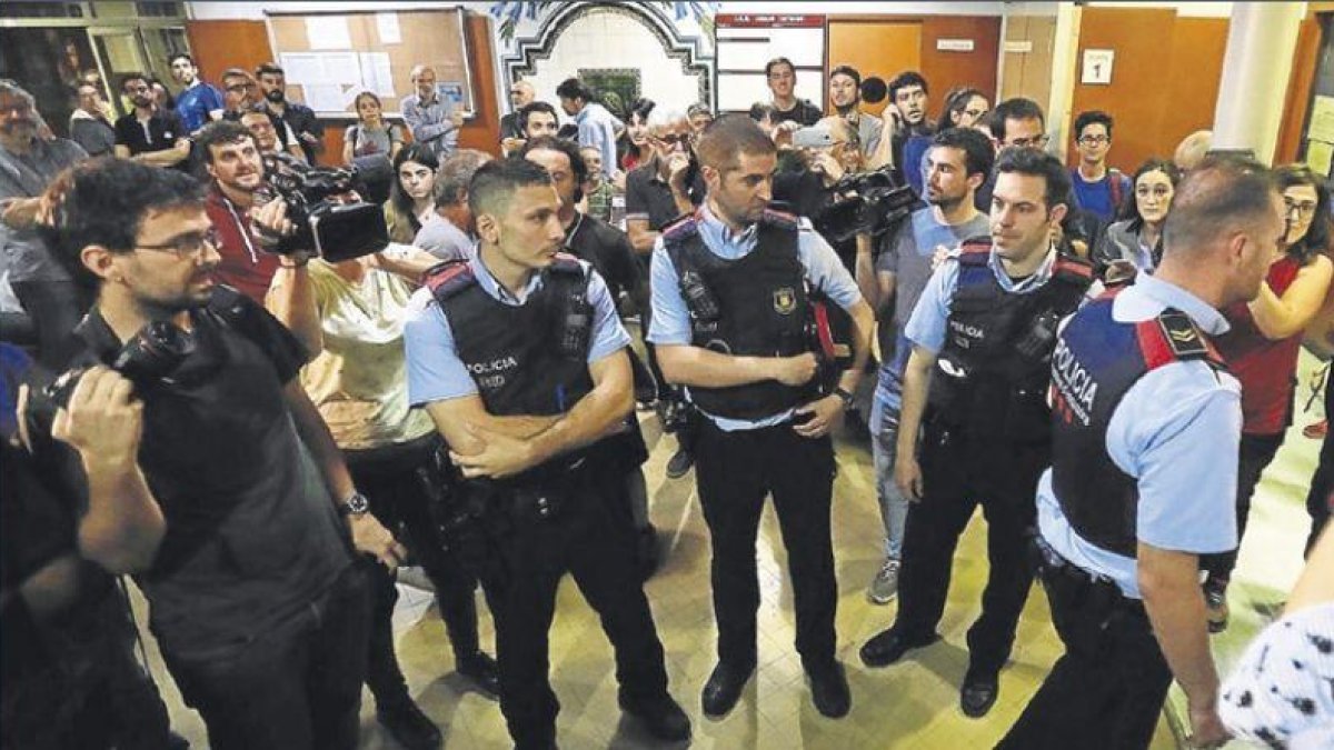 Un grupo de mossos d’esquadra en el instituto Miquel Tarradell, del barrio barcelonés del Raval, ayer.-FERRAN NADEU
