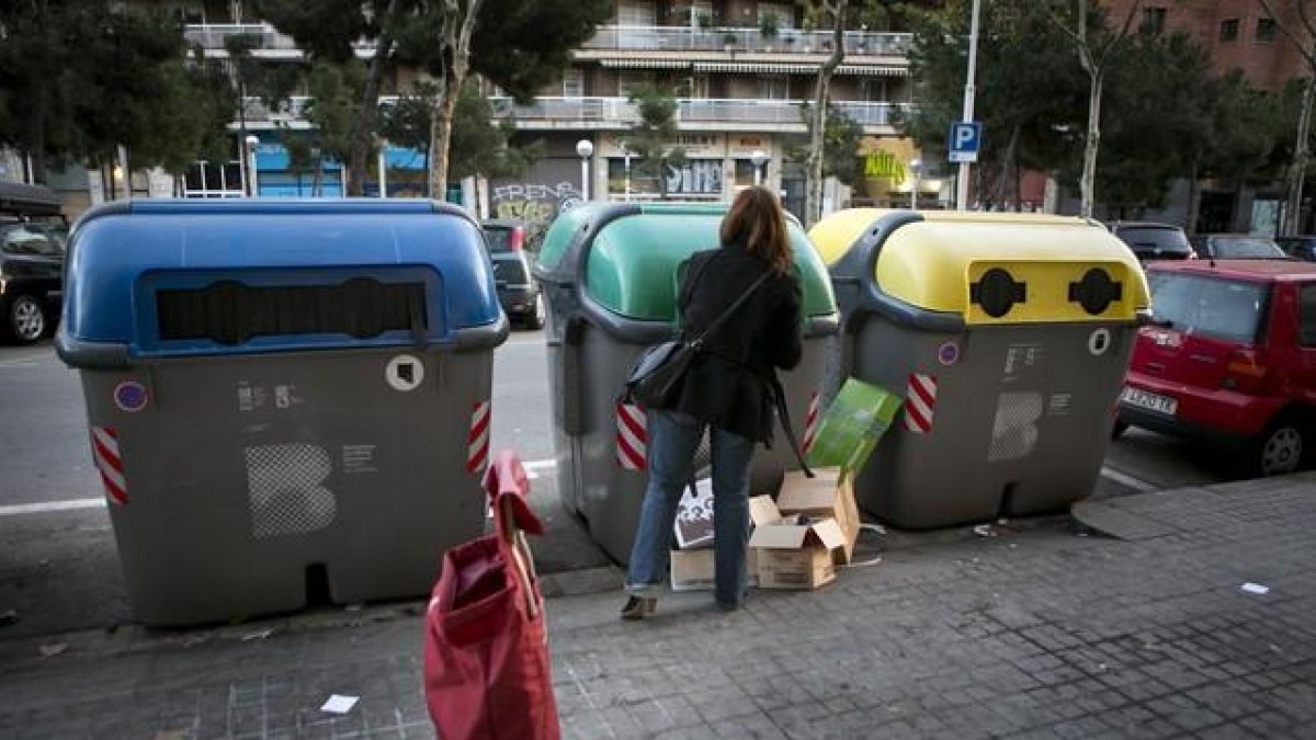 Una mujer deposita residuos en contenedores.-ARCHIVO