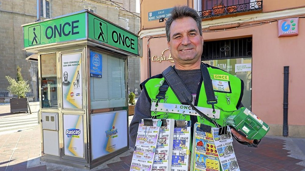 El vendedor de la localidad vallisoletana de Pollos, Vicente Macías, junto a su puesto de la ONCE.-J. M. LOSTAU