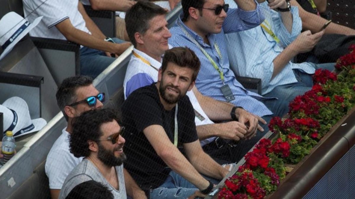 Piqué, en la grada de la pista Manolo Santana de la Caja Mágica de Madrid.-REUTERS