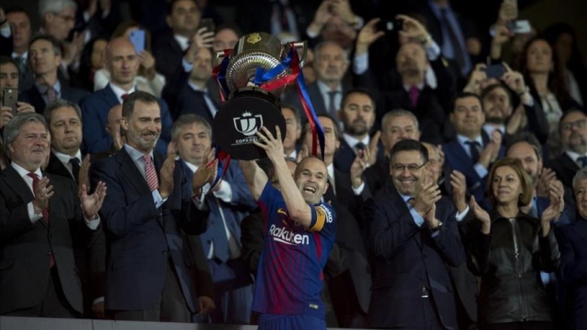 Iniesta recoge la copa del ganador durante la final de la Copa del Rey.-JORDI COTRINA