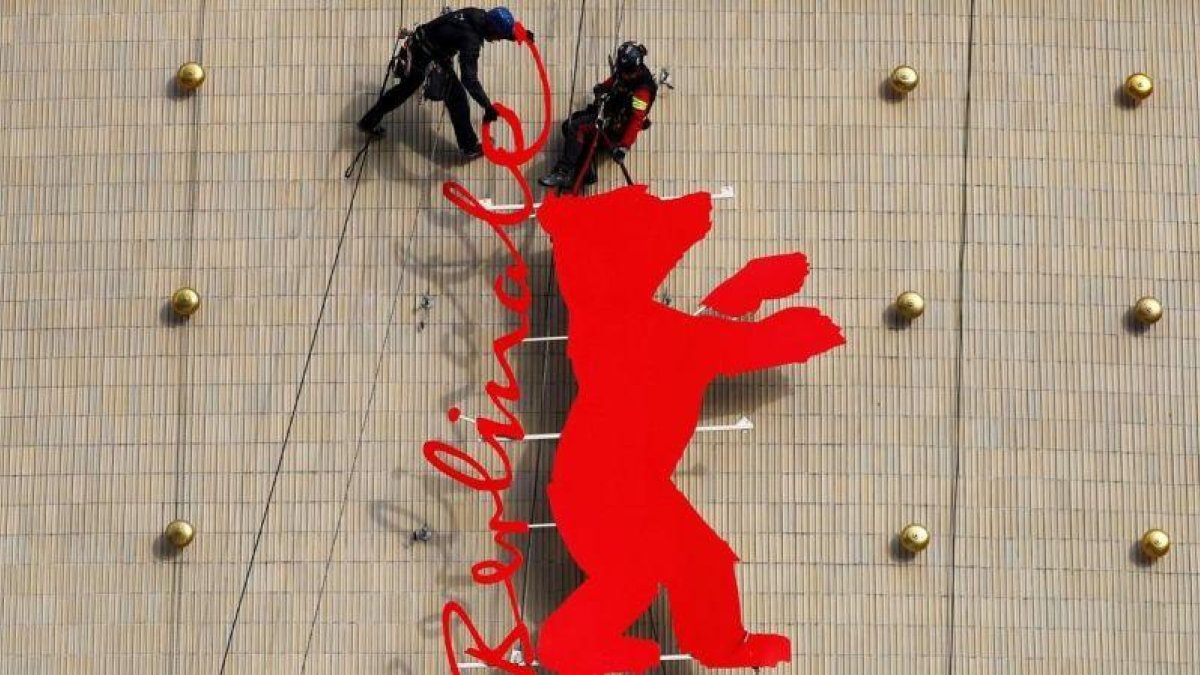 Unos operarios fijan el logo de la Berlinale en el cine Zoo Plast, una de las sedes del festival de Berlín, este miécoles.-REUTERS / FABRIZIO BENSCH