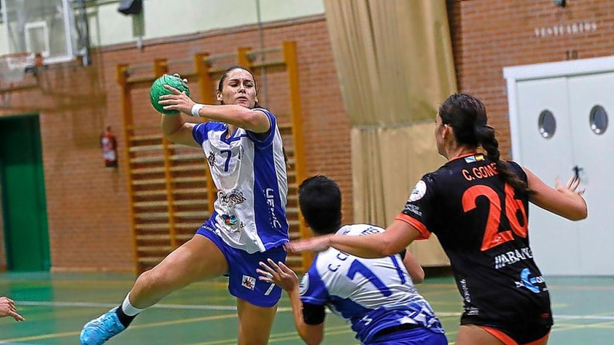 EliCesáreo (máxima goleadora del partido) se eleva para lanzar por encima de Cristina Cifuentes y Clara Gómez.-J. M. LOSTAU
