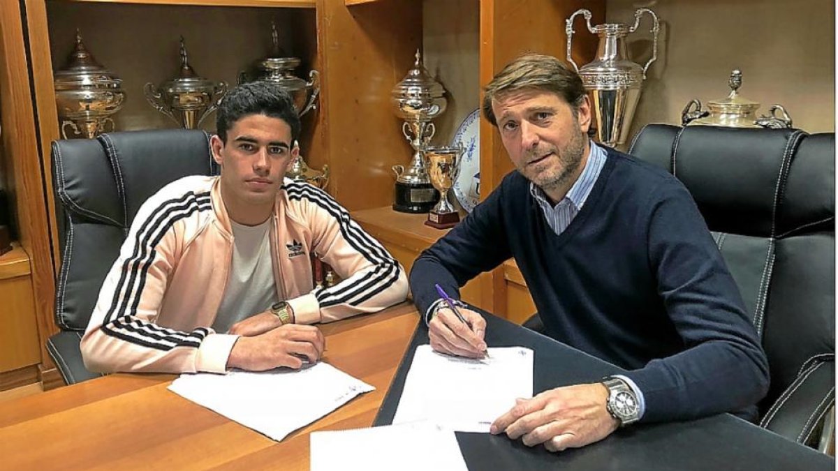 El canterano blanquivioleta Miguel de la Fuente y el presidente Carlos Suárez recrean una firma del contrato.-REAL VALLADOLID