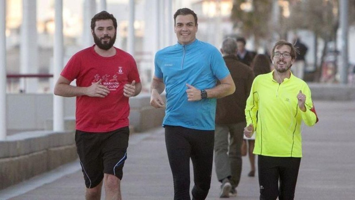 Pedro Sánchez corre junto a dos simpatizantes, este lunes en Cádiz.-EFE / ROMÁN RÍOS