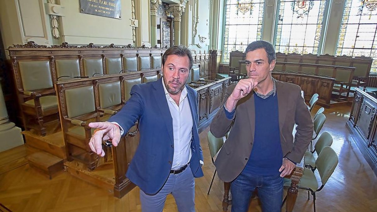 Óscar Puente señala a Pedro Sánchez el lugar que ocupa en la presidencia del salón de plenos del Ayuntamiento de Valladolid durante su visita.-PABLO REQUEJO