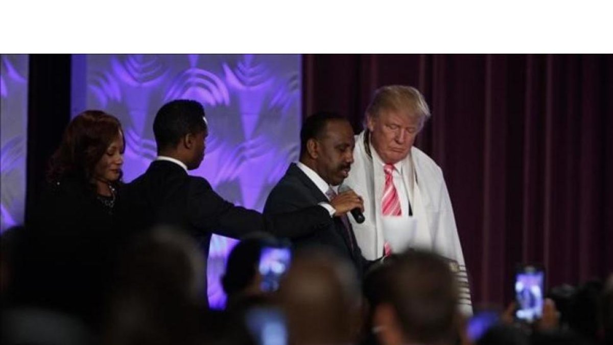 Donald Trump con una túnica de oración durante la visita a una iglesia negra en Detroit.-EVAN VUCCI / AP