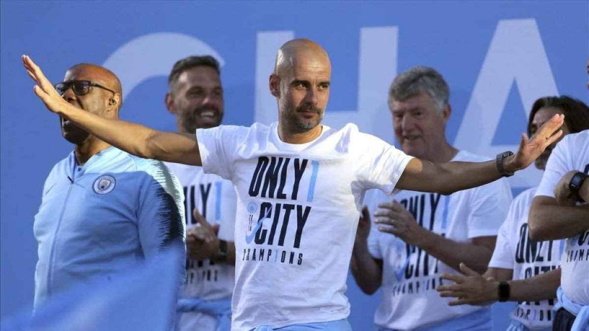 Guardiola festeja su primera Premier por las calles de Manchester.-/ AP / RICHARD SELLERS