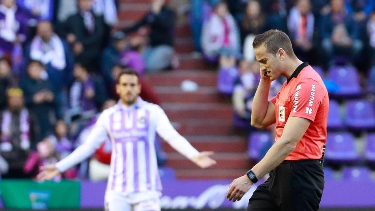 Kiko Olivas, al fondo, pide explicaciones mientras Alberola Rojas recibe indicaciones del VAR en el partido frente a la Real Sociedad.-J. M. LOSTAU