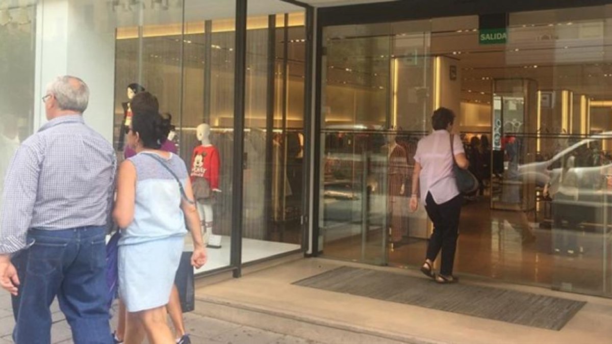 Una pareja pasea por delante de un escaparate de un comercio de ropa.-EUROPA PRESS