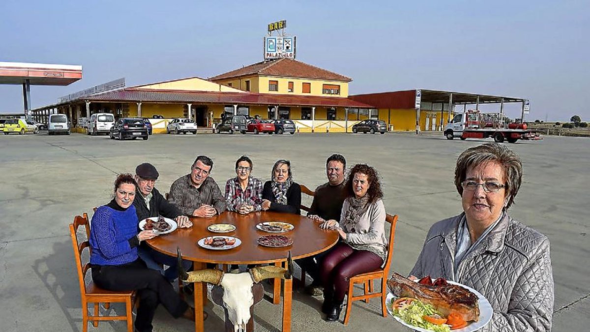 Mari Carmen Amez, en primer término, con un chuletón de búfalo, y su familia detrás. De i. a d.: Miriam, Carlos, Eduardo, Camino, Laura, Juan y Ana.-ARGICOMUNICACIÓN