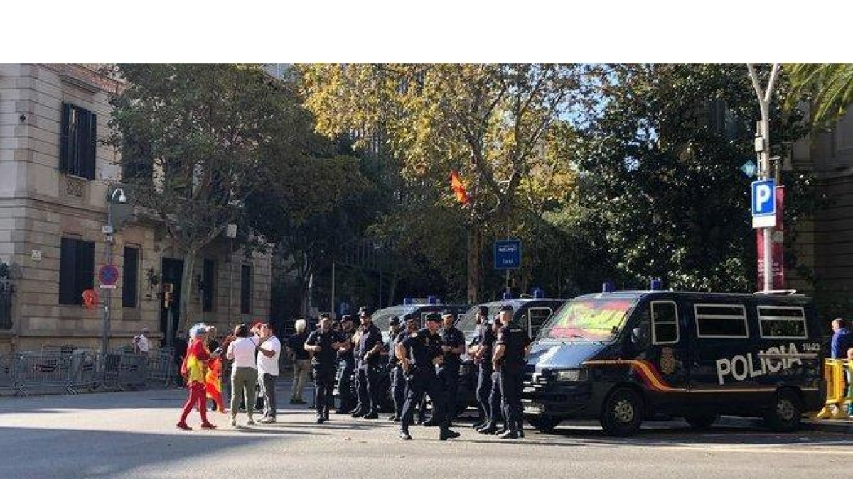 Varias personas saludan a unos agentes de la Policía Nacional, en Barcelona.-JÚLIA REGUÉ