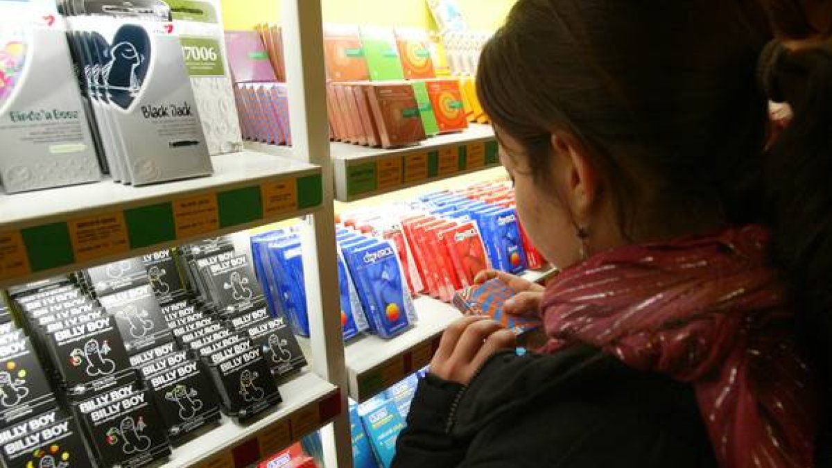 Una chica, frente a un estante repleto de preservativos en una tienda especializada de Barcelona.-Foto: SERGIO LAINZ