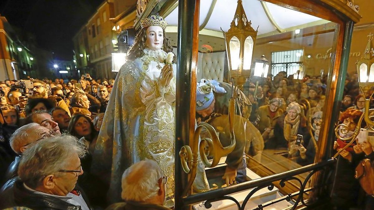 Un ‘mulero’ introduce la imagen de la Virgen en el carruaje, ante la mirada de cientos de espectadores.-PABLO REQUEJO