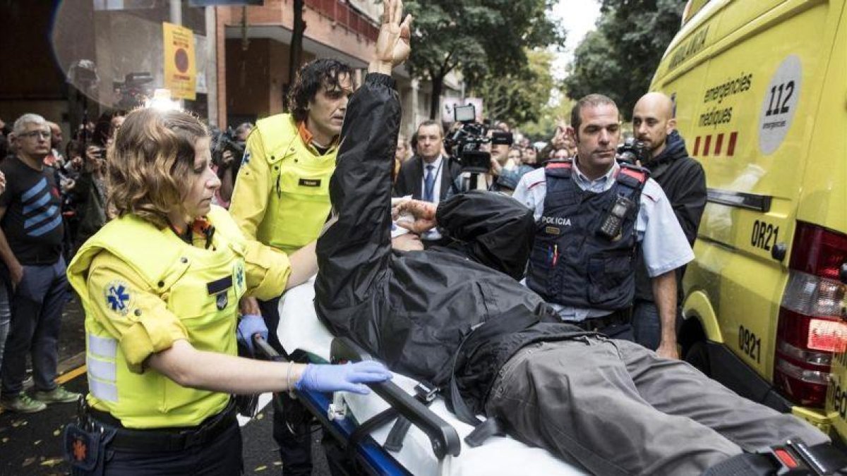 Roger Español es trasladado a un hospital tras recibir el impacto de una pelota de goma durante las cargas de la Policía Nacional en el colegio Ramon Llull durante el referendum del 1-O.-FERRAN NADEU