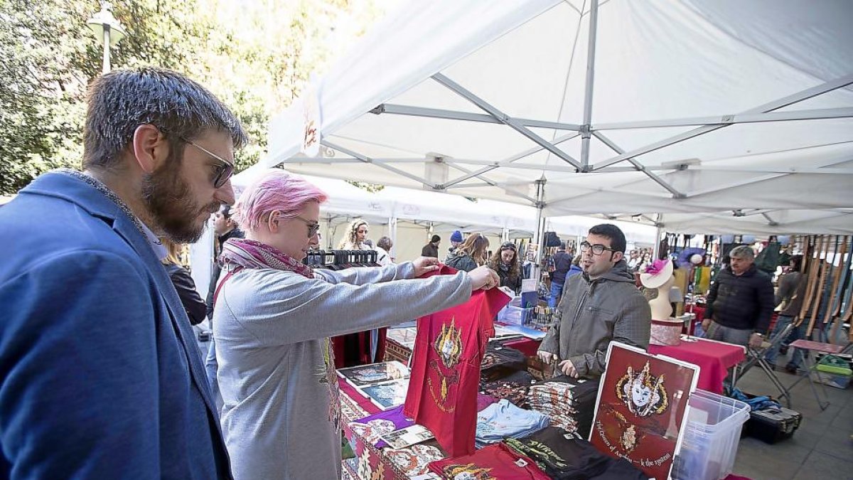 Dos clientes del mercado de la calle Ferrari interactuan con el artesano.-JOSE C. CASTILLO (PHOTOGENIC)