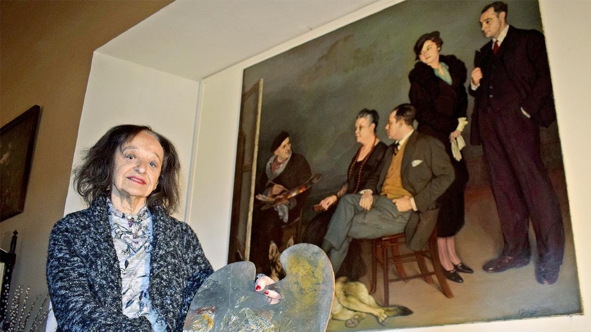 María Rosa Suárez Zuloaga, en el Museo Ignacio Zuloaga del Castillo de Pedraza (Segovia) y, detrás de ella, la célebre obra La Familia, de 1937, donde el pintor se retrata junto a Valentine, sus dos hijos, Lucía y Antonio, y su yerno Enrique.-ARGICOMUNICACIÓN