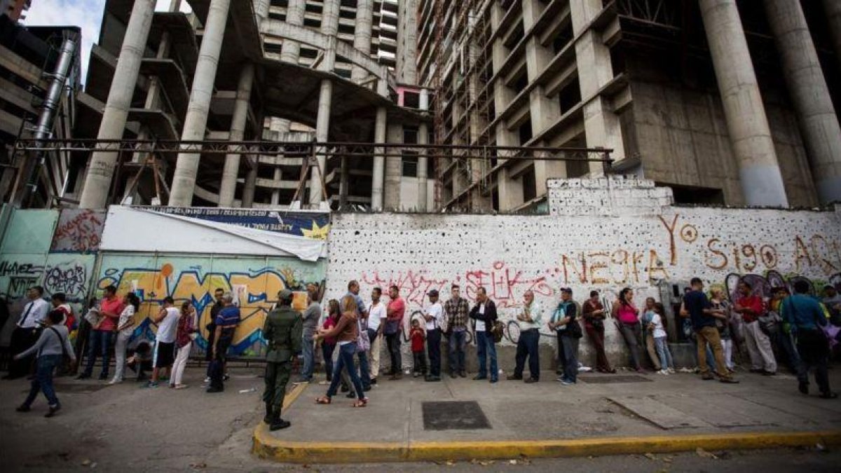 Un grupo de personas aguardan para realizar transacciones bancarias, en Caracas, el 13 de diciembre.-EFE / MIGUEL GUTIERREZ