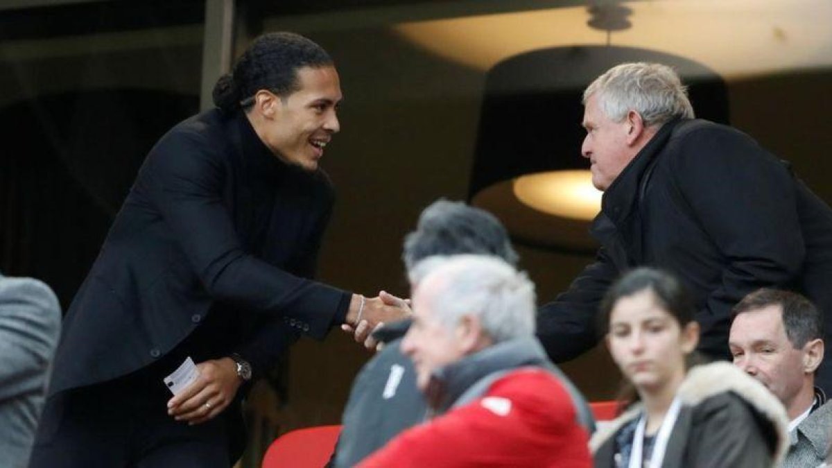 El golfista Colin Montgomerie, a la derecha, da la bienvenida al holandés Virgil van Dijk, en Anfield.-CARL RECINE