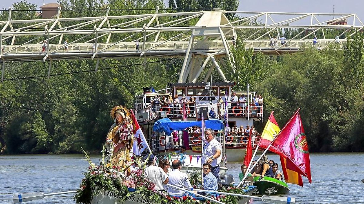 La Virgen del Carmen durante la procesión seguida del barco La Leyenda del Pisuerga.-J. M. LOSTAU