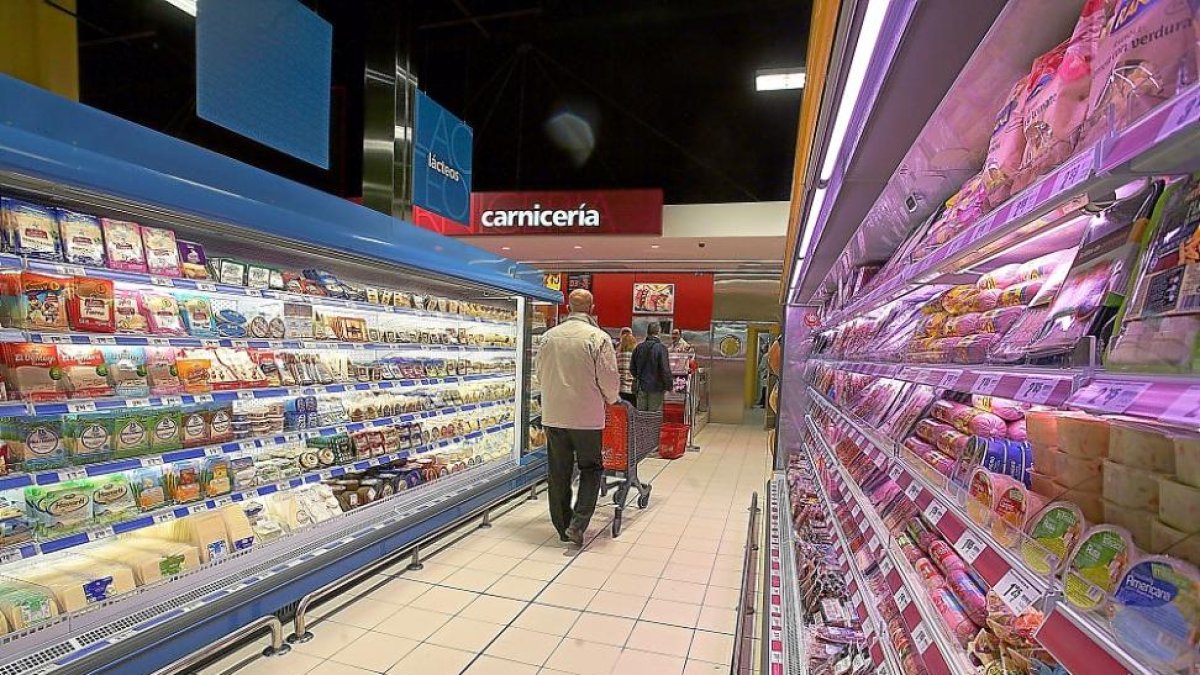Varias personas realizan la compra en un supermercado.-E.M.