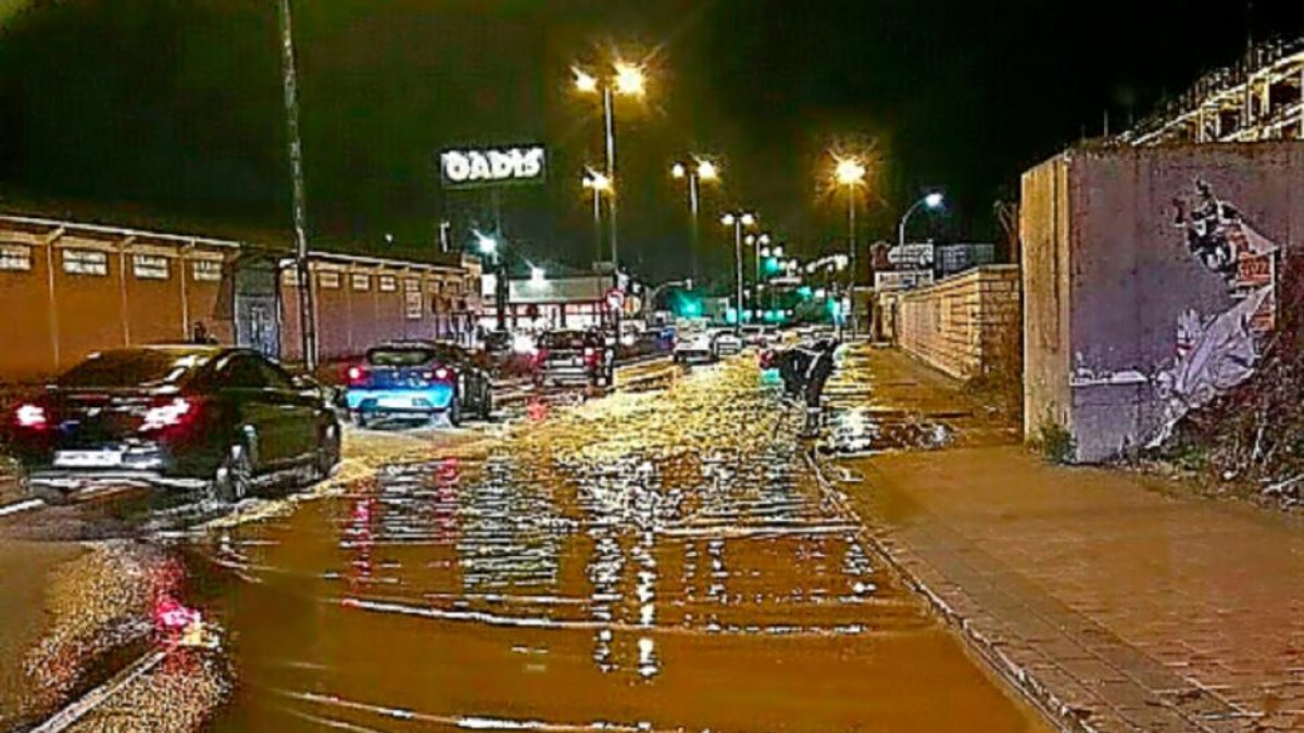 Un bombero levanta una rejilla para facilitar el achique.-E. M.