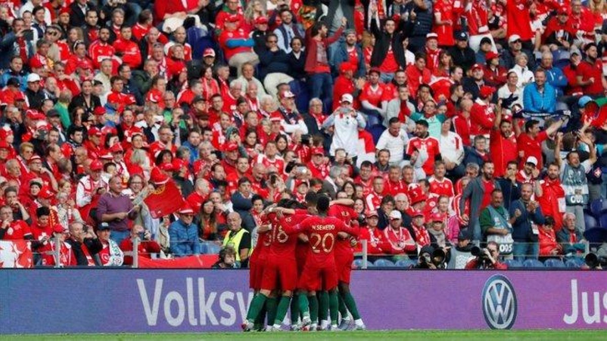 Cristiano Ronaldo, rodeado de sus compañeros portugueses tras marcar el primer gol.-EL PERIÓDICO