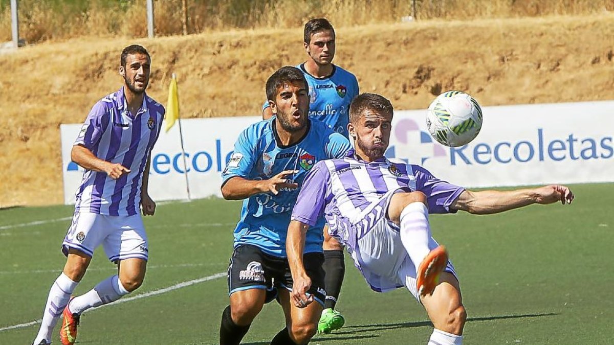 Dani Vega intenta bajar el balón ante dos jugadores del Boiro-J. M. LOSTAU