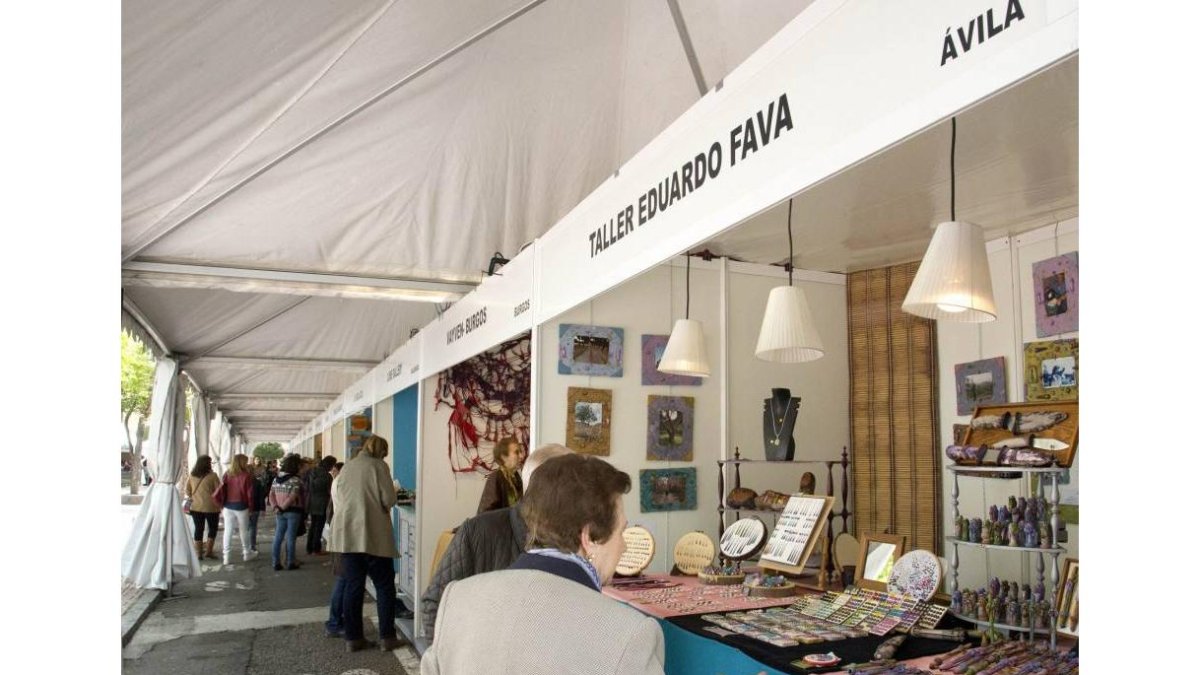 Unos paseantes observan los puestos de la Feria de Artesanía-Ical