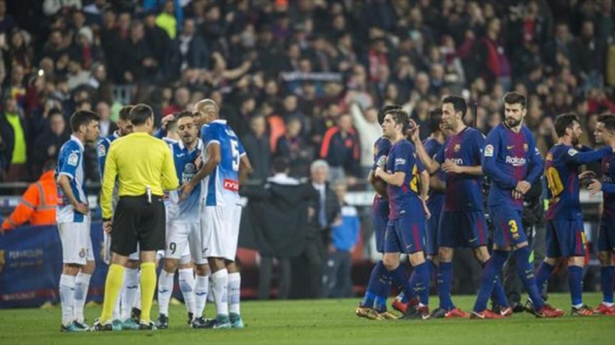 PROTESTA FINAL Los jugadores del Espanyol protestan al árbitro mientras los futbolistas del Barça celebran la clasificación para las semifinales de Copa, ayer, en el Camp Nou.-/ JORDI COTRINA
