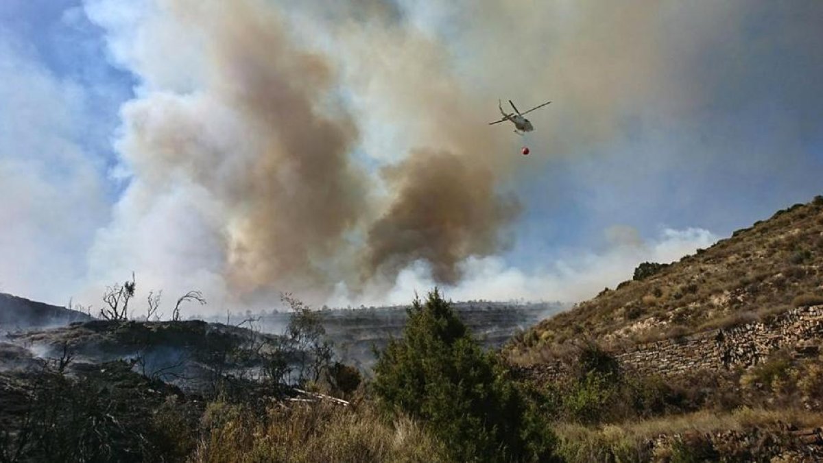 Uno de los helicópteros trabajando en las tareas de extinción ayer en Cigudosa.-D. S.