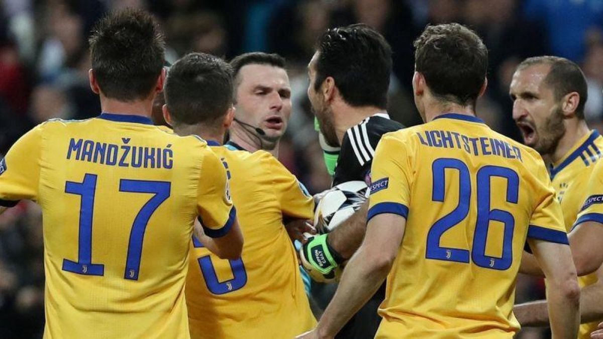 El árbitro Michael Oliver, acosado por los jugadores de la Juve.-REUTERS / SUSANA VERA