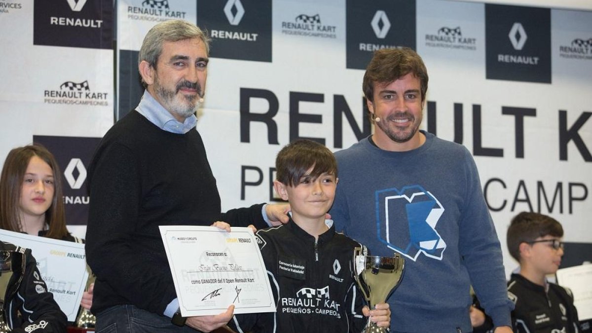 Iván Bueno recibe el premio de campeón de manos del ‘dircom’ de Renault, Jesús Presa, ante un sonriente Fernando Alonso.-RENAULT