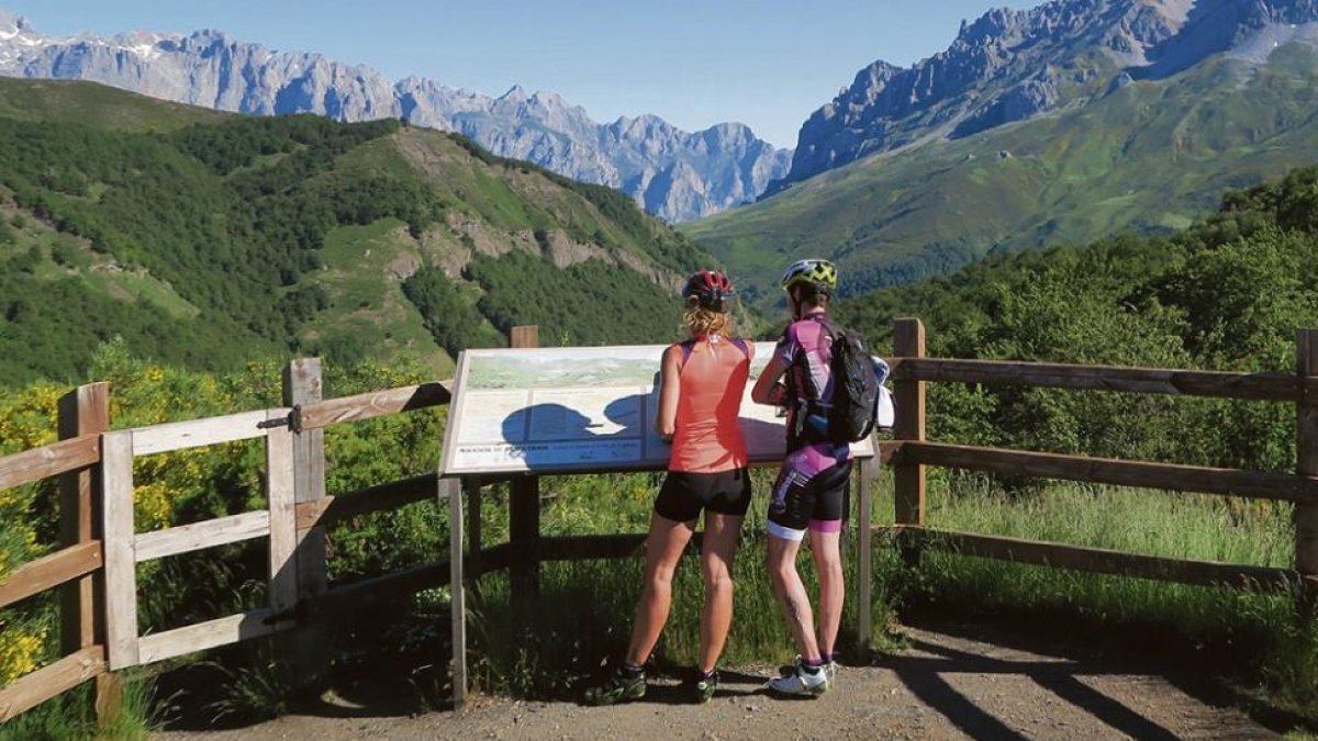 Dos ciclistas asomados al mirador de Pandetrave, ante las Torres del Friero, Hoyochico, Liordes y Salinas.-ICAL