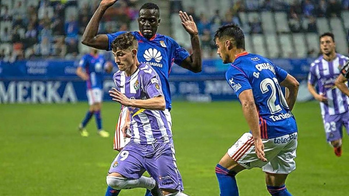 Toni progresa con el balón ante los oviedistas Mariga y Cotugno.-PHOTO-DEPORTE