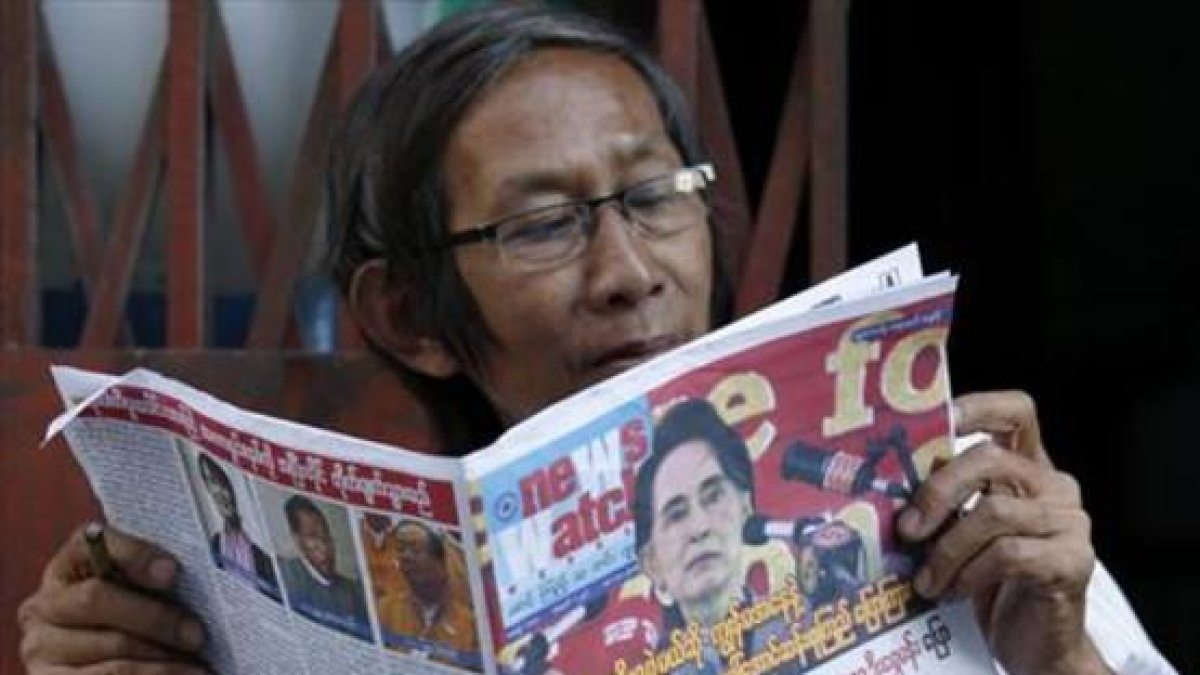 Un birmano lee un periódico donde Suu Kyi aparece en portada, este sábado.-EFE / RUNGROJ YONGRIT