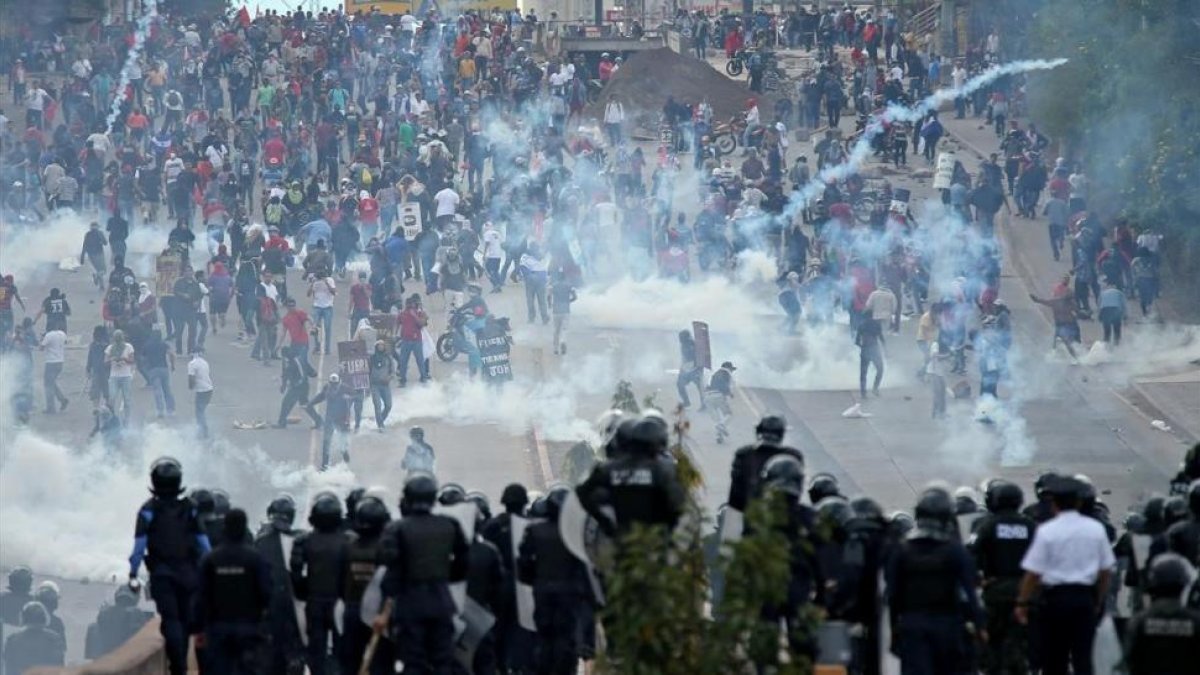 Opositores y policía se enfrentan cerca del Estadio Nacional de Tegucigalpa antes de la toma de posesión del presidente de Honduras, Juan Orlando Hernández.-/ REUTERS / EDGARD GARRIDO