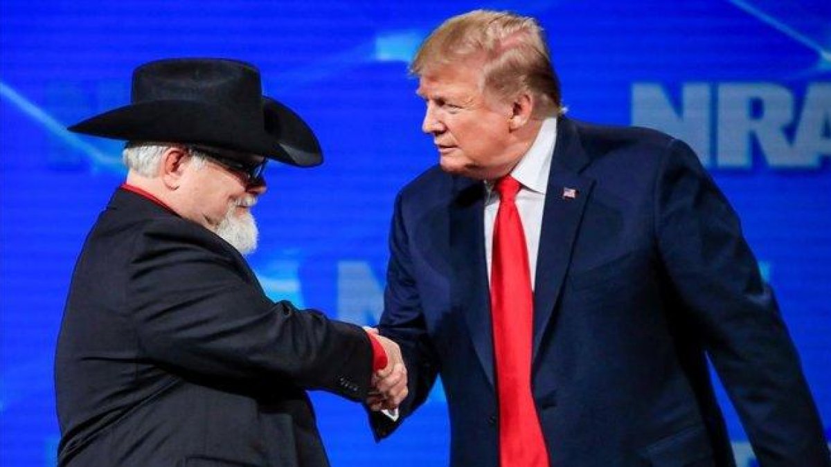 Donald Trump saluda a un asistente a la reunión de la Asociación Nacional del Rifle.-EFE / TANNEN MAURY