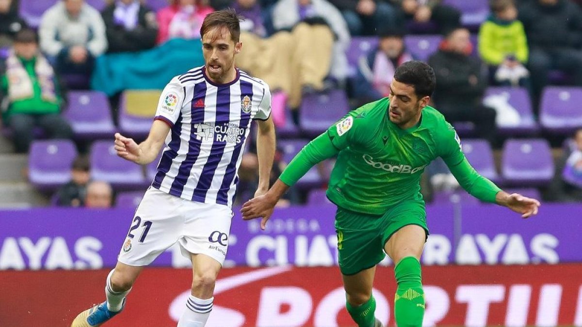 Míchel conduce el balón ante Merino en el partido frente a la Real Sociedad.-J. M. LOSTAU