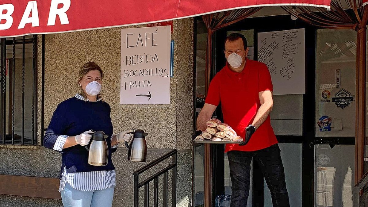 Héctor Tomás (d) y su mujer Sandra Hernández (i) a las puertas del establecimiento donde dejan bocadillos, café caliente e infusiones a los camioneros que hacen parada en su ruta . /L.P.