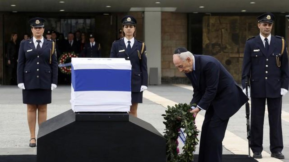El presidente israelí Shimon Peres rinde tributo al exprimer ministro fallecido el sábado.-GALI TIBBON / AFP