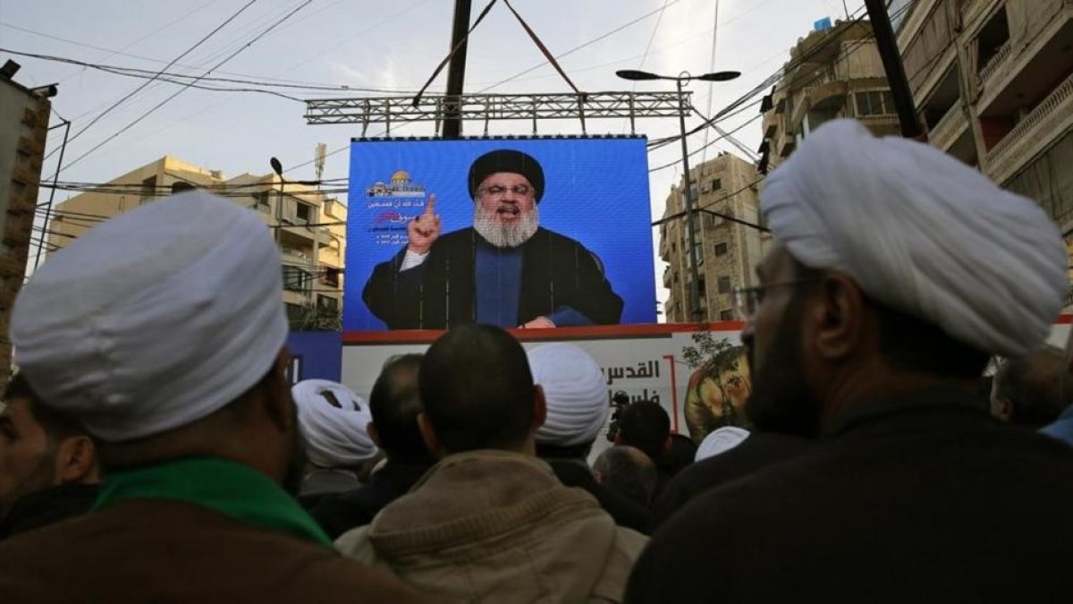 Seguidores de Hizbulá escuchan a su líder que aparece en una pantalla gigante en una manifestación en Beirut.-/ BILAL HUSSEIN / AP